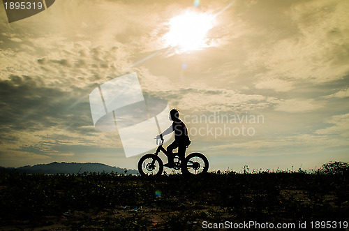 Image of Silhouette of kid riding a bicycle