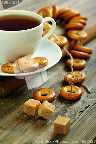 Image of Cup of tea and small bagels with poppy seeds.