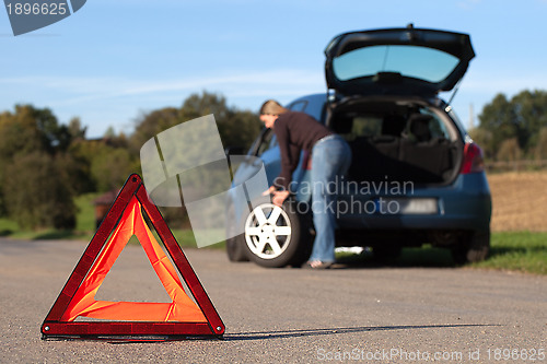 Image of Broken down car with red warning triangle