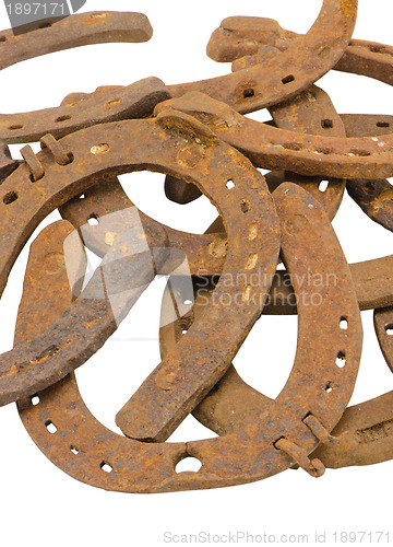 Image of stack of old retro horse shoes isolated on white 