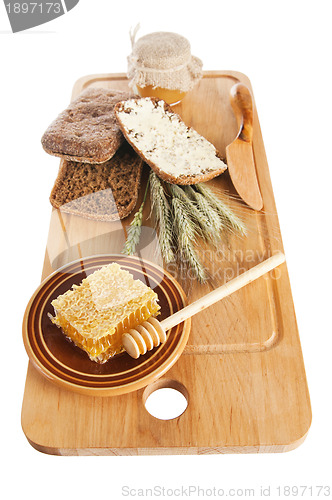 Image of honey, spike and bread on table 