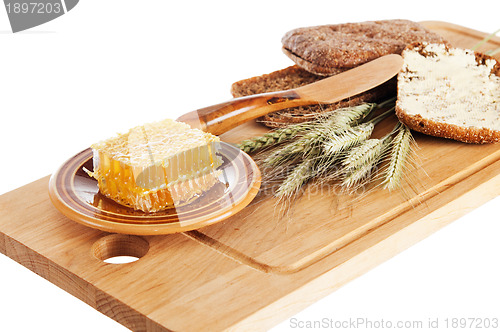 Image of honey, spike and bread on table 