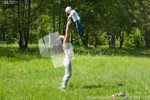 Image of Mother raising her little child up high