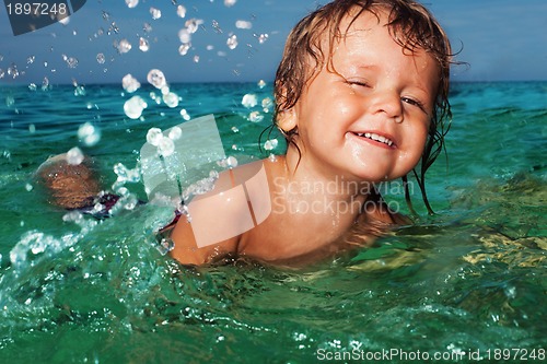 Image of Happy kid splashing in the sea