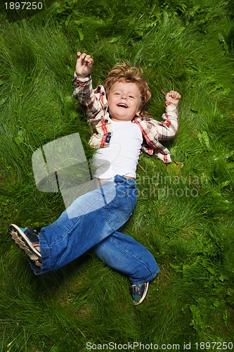 Image of laughing boy rolling on grass