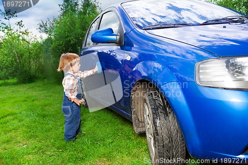 Image of adorable child helping to wash car