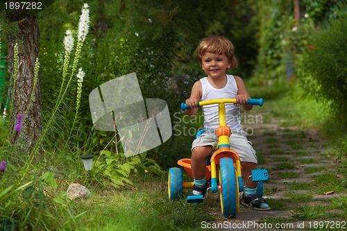 Image of little boy riding tricycle