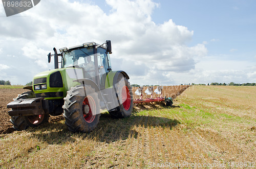 Image of Closeup tractor plowing agricultural field autumn 