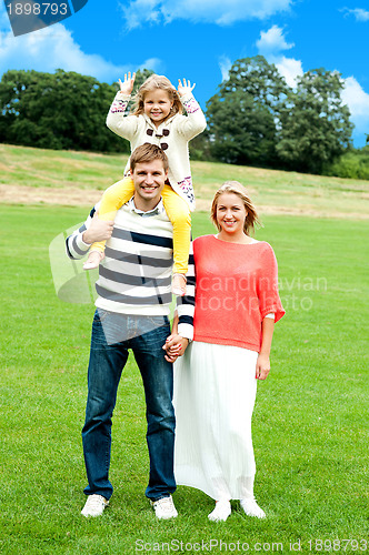 Image of Family of three posing against natural background