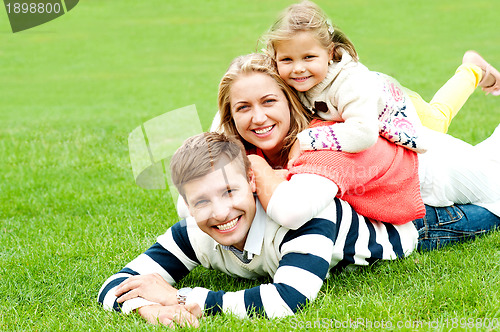 Image of Husband, wife and child piled on each other