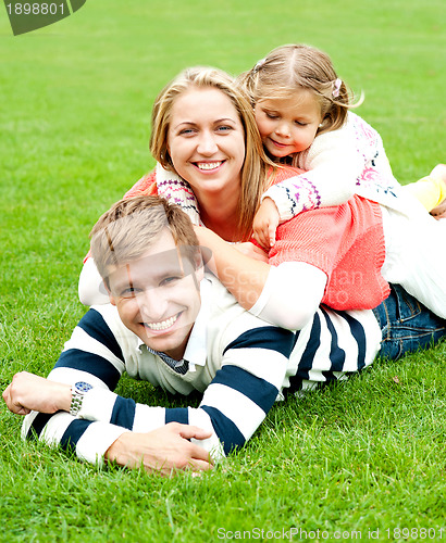 Image of Young mother sandwiched between her daughter and husband