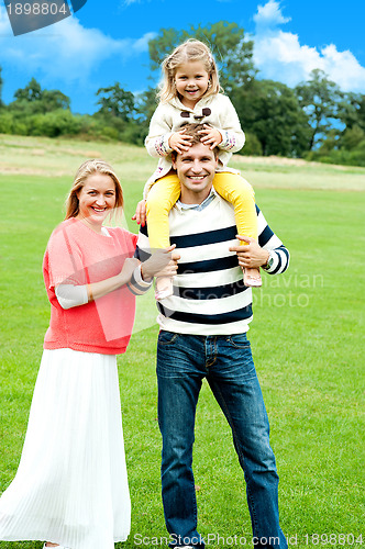 Image of Cheerful family posing against nature background