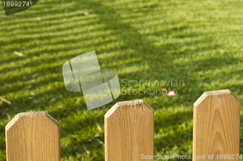 Image of Wooden decorative fence and green garden