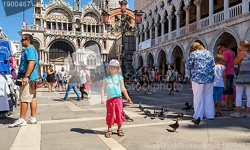 Image of 16. Jul 2012 - Small girl with pigeons in St Marco Square, in front of Doge's Palace in Venice, Italy