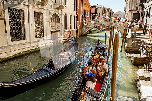 Image of 16. Jul 2012 - Gondoliers with tourists at canal in Venice, Italy