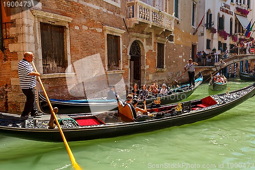 Image of 16. Jul 2012 - Gondolier with tourists at canal in Venice, Italy