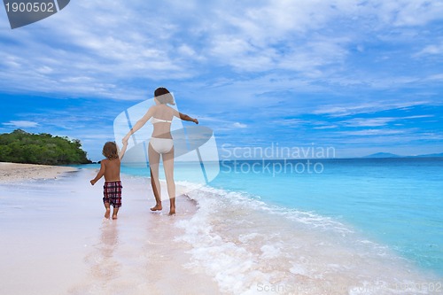 Image of mom and son running on seashore
