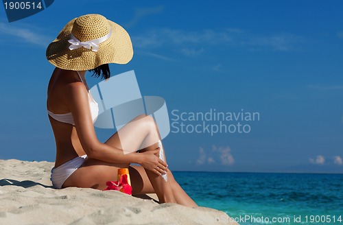 Image of Slim woman applying sunscreen