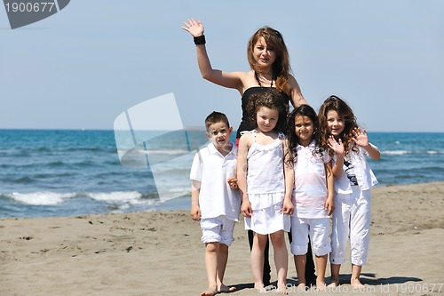 Image of group portrait of childrens with teacher on beach