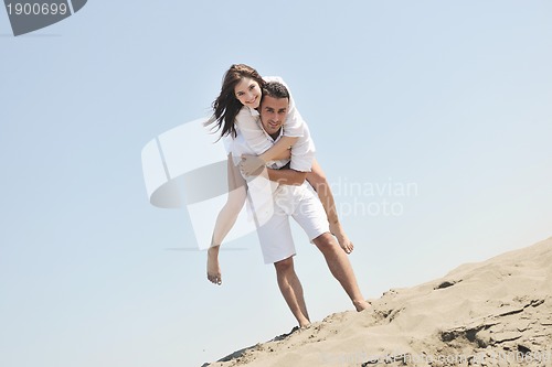 Image of happy young couple have fun on beach
