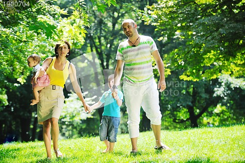Image of happy young couple with their children have fun at park