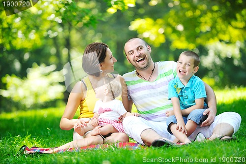 Image of happy young couple with their children have fun at park