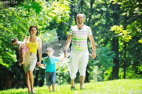Image of happy young couple with their children have fun at park