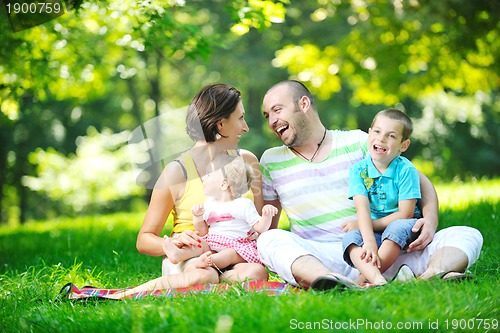 Image of happy young couple with their children have fun at park