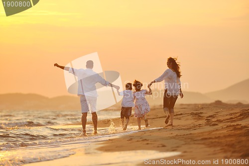 Image of happy young family have fun on beach at sunset