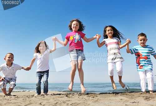 Image of happy child group playing  on beach