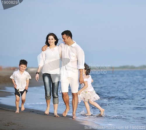 Image of happy young family have fun on beach at sunset