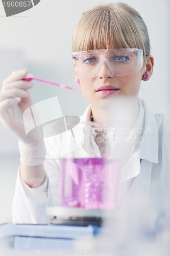 Image of female researcher holding up a test tube in lab