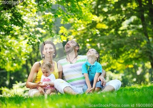 Image of happy young couple with their children have fun at park