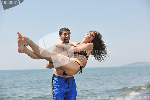 Image of happy young couple have fun on beach