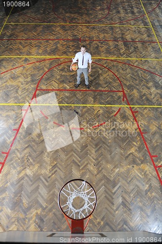 Image of businessman holding basketball ball