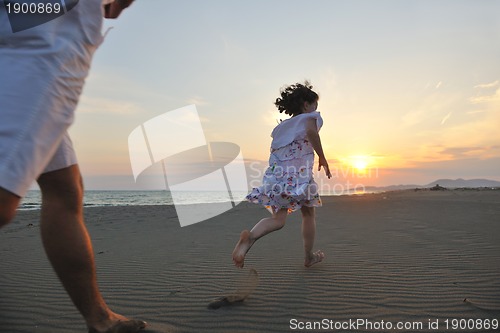 Image of happy young family have fun on beach at sunset