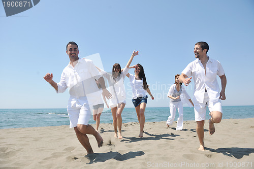 Image of happy people group have fun and running on beach