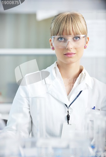 Image of female researcher holding up a test tube in lab