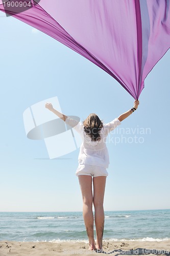 Image of beautiful young woman on beach with scarf