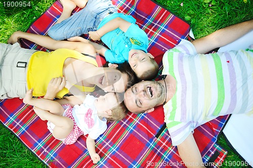 Image of happy young couple with their children have fun at park