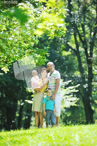 Image of happy young couple with their children have fun at park