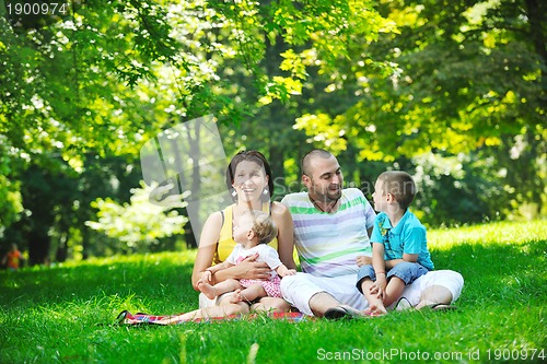 Image of happy young couple with their children have fun at park
