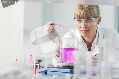 Image of female researcher holding up a test tube in lab