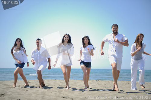 Image of happy people group have fun and running on beach
