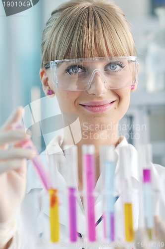 Image of female researcher holding up a test tube in lab