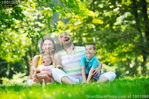 Image of happy young couple with their children have fun at park