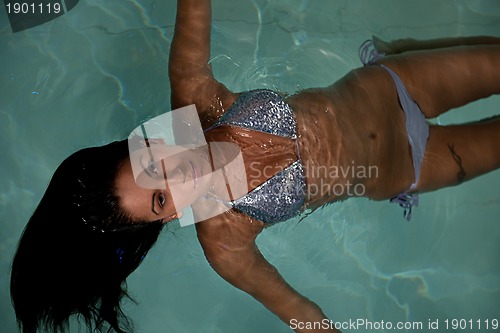 Image of pretty young lady  relaxing in the swimming pool