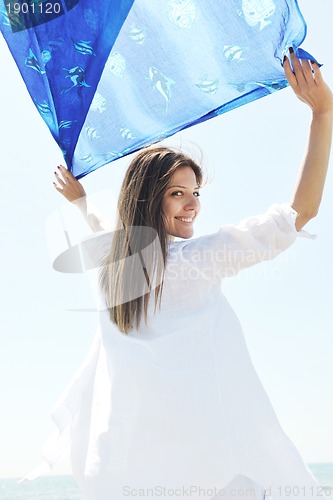 Image of beautiful young woman on beach with scarf