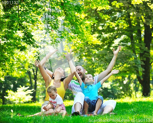 Image of happy young couple with their children have fun at park