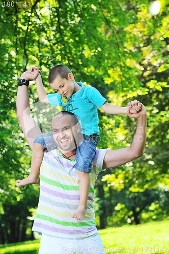 Image of happy father and son have fun at park